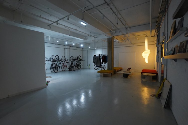 Ground-floor shared area with bicycle storage, seating and a hanging light sculpture.