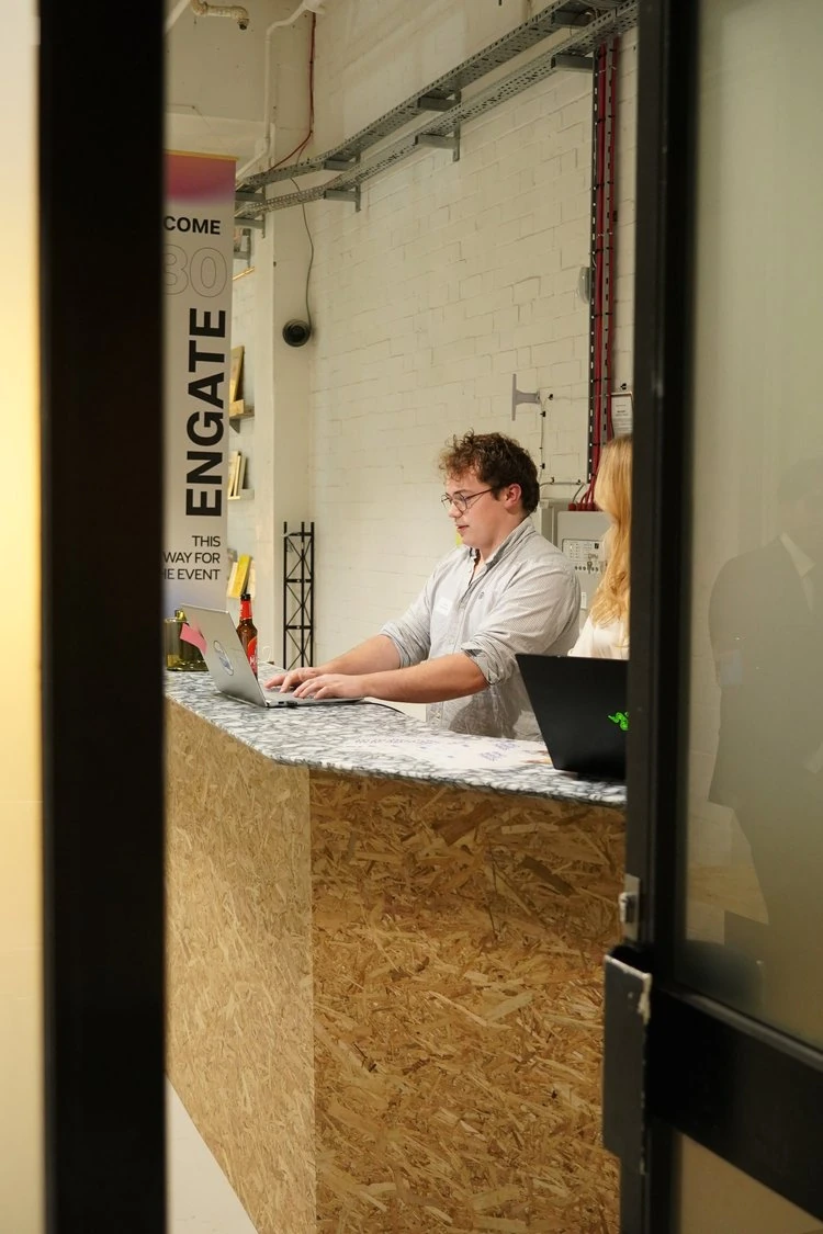 A person working at a laptop at the 30 Engate reception counter.