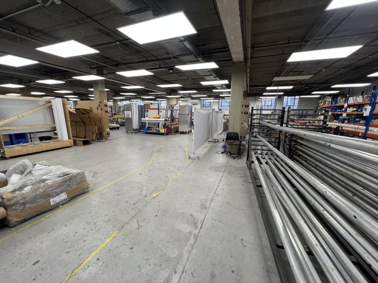Industrial storage area with long metal stock on racks.