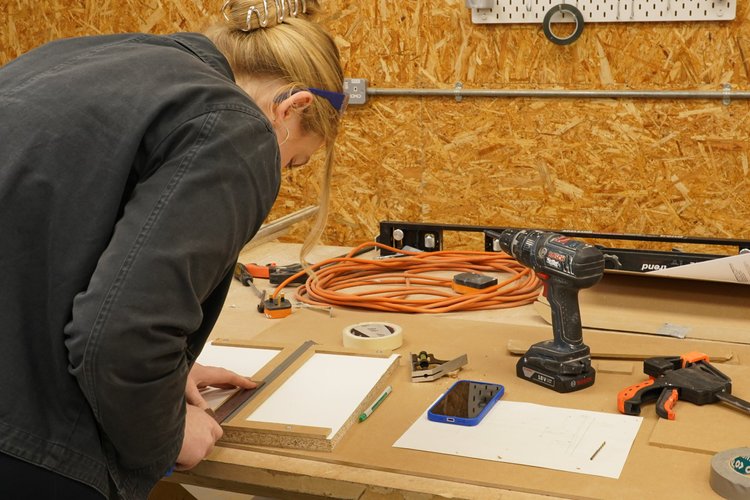 A maker working with wood and tools in the workshop