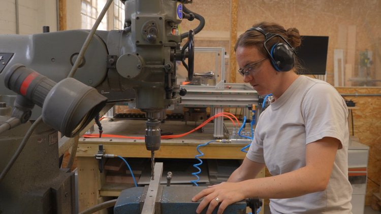 A maker working at a machine inside Blue Garage